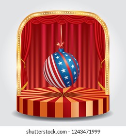 American flag on a christmas ball hanging on a string on stage with red curtain


