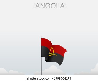 The Angolan flag flutters on a pole standing tall under a white sky