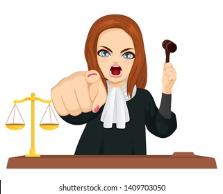 Angry female judge in courtroom holding gavel and pointing finger