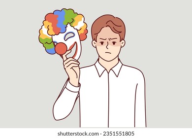 Angry man takes off mask happy clown for concept of duplicity and hypocrisy person pretending to be jester. Metaphor bipolar disorder in guy demonstrating hypocrisy when communicating or working