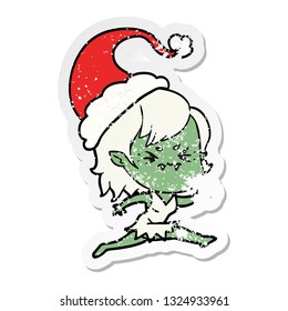 annoyed hand drawn distressed sticker cartoon of a vampire girl wearing santa hat