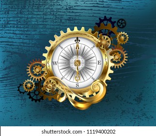 Antique compass with gold and brass gears on turquoise wooden background.
