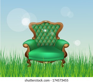 antique luxury chair with wooden legs and upholstered in green. Interior piece of furniture on a background of green grass