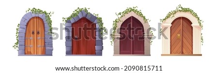 Antique medieval wooden door with metal handle, stone arch and climbing ivy plant. Gothic entrance, gate in a castle, church or house.