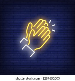 Applause neon sign. Glowing neon two clapping hands on brick wall background. Vector illustration can be used for gesturing, communication, chatting