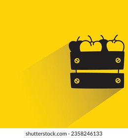 apple in crate with shadow on yellow background