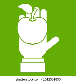 Apple in hand icon white isolated on green background. Vector illustration