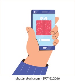 An application for ordering Christmas gifts online. Hand holding phone, gift on screen