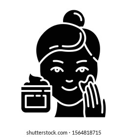Applying cream glyph icon. Skin care procedure. Facial beauty treatment. Face product for lifting and exfoliating. Cosmetics, makeup. Silhouette symbol. Negative space. Vector isolated illustration