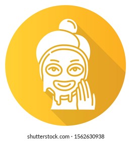 Applying liquid mask yellow flat design long shadow glyph icon. Skin care procedure. Facial beauty treatment. Face product for lifting and exfoliating effect. Makeup. Vector silhouette illustration
