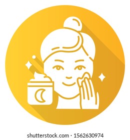 Applying night cream yellow flat design long shadow glyph icon. Skin care procedure. Facial treatment product. Sleeping cream for evening beauty routine. Vector silhouette illustration