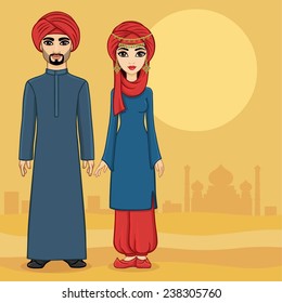  Arab family in traditional clothes against the desert and ancient city. Full growth.
