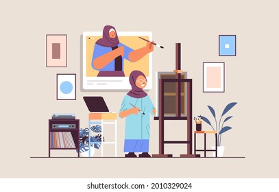 arab schoolgirl with female teacher artist in web browser window painting picture during video call self isolation