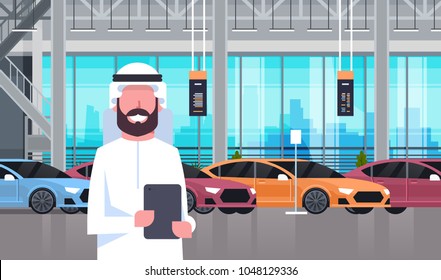 Arab Seller Man In Cars Dealership Center Showroom Interior Over Set Of New Modern Vechicles