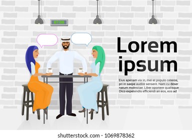 Arab Waiter Serving Two Muslim Women Drinking Coffee In Modern Cafe And Talking