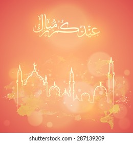 Arabic calligraphy text of Eid Mubarak with mosque on shiny orange background for muslim community festival celebration.