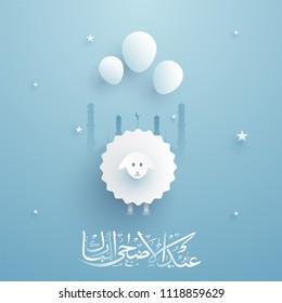 Arabic calligraphy text Eid-Al-Adha, Festival of sacrifice with paper-art illustration of sheep and balloons, mosque, stars on blue background.