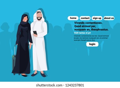 Arabic couple using smartphone holding valise wearing traditional clothes.  Travel concept with man woman cartoon character avatars.  Blue background full length horizontal copy space flat