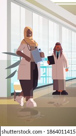 médicos árabes en pareja uniformados de pie hombres mujeres profesionales de la medicina discutiendo durante la reunión de la medicina concepto de salud clínica interior vertical de longitud completa ilustración vectorial