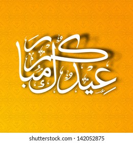 Arabic Islamic calligraphy of text Eid Mubarak on abstract orange background.