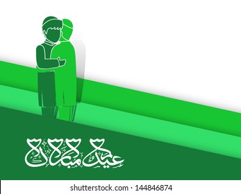 Arabic Islamic calligraphy of text Eid Mubarak with green silhouette of  two muslim young mans in traditional dress hugging and wishing to each other on occasion of Eid.