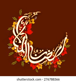 Arabic Islamic calligraphy of text Ramadan Mubarak in moon shape decorated with colorful flowers on brown background. 