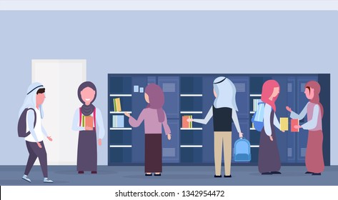 arabic schoolchildren group taking books out of lockers muslim pupils in hijab modern school corridor interior education concept horizontal full length flat