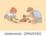 Archaeologists at excavations of ancient city clean artifacts of medieval civilizations at site of old temple. Young man and woman working archaeologists found ancient burials of cultural value