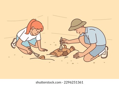 Archaeologists at excavations of ancient city clean artifacts of medieval civilizations at site of old temple. Young man and woman working archaeologists found ancient burials of cultural value