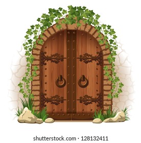 Arched medieval wooden door in a stone wall, with ivy