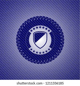 armor icon inside badge with denim texture