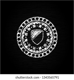 armor icon inside chalkboard emblem written on a blackboard