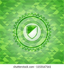 armor icon inside green emblem. Mosaic background