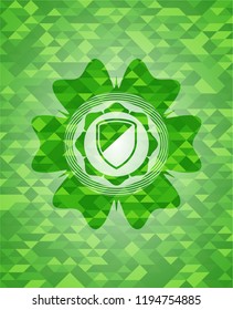 armor icon inside green emblem with triangle mosaic background