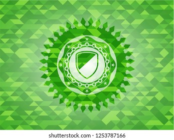 armor icon inside green emblem with triangle mosaic background