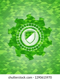 armor icon inside green emblem. Mosaic background