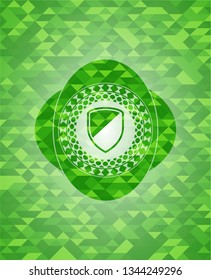 armor icon inside green emblem. Mosaic background