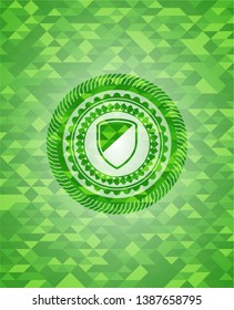 armor icon inside green emblem. Mosaic background