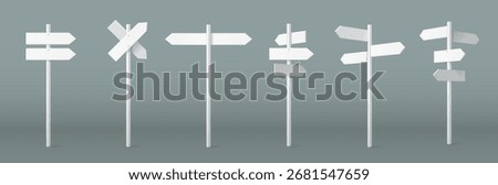 Arrow sign on pole set with white directional markers on posts for wayfinding and navigation systems. Crossroad signposts with multiple pointing boards for outdoor guidance. Street direction indicator