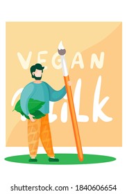 The artist stands with a large brush in his hands and several leaves under his arm against the background of a painting with an inscription. Vegan milk concept. Promotion of healthy lifestyle