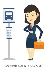 Asian business woman waiting at the bus stop. Young business woman standing at the bus stop. Woman looking at her watch at the bus stop. Vector flat design illustration isolated on white background.