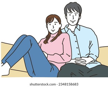 Asian couple cuddling while sitting on sofa indoors