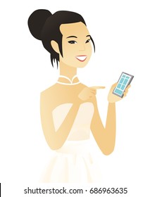 Asian fiancee holding a mobile phone and pointing at it. Young fiancee with a mobile phone. Fiancee using a mobile phone. Vector flat design illustration isolated on white background.
