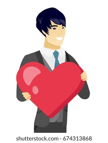 Asian groom in a wedding suit showing a big red heart. Young groom with heart shape. Happy groom holding a red heart. Vector flat design illustration isolated on white background.
