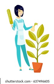 Asian housemaid in uniform watering the flower with spray. Full length of young housemaid with flower. Home cleaning service concept. Vector flat design illustration isolated on white background.