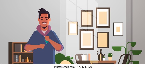 asian man applying antibacterial spray covid-19 virus bacteria disinfection stop coronavirus pandemic quarantine concept living room interior horizontal portrait vector illustration