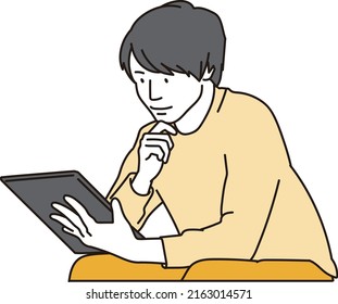 Asian Man Looking At A Tablet To Kill Time