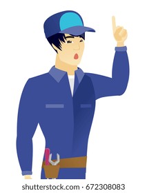 Asian mechanic with open mouth pointing finger up. Young mechanic with open mouth came up with successful idea. Vector flat design illustration isolated on white background.