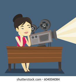 Asian projectionist showing new film. Woman sitting at the table with film projector in the room of projectionist. Young projectionist at work. Vector flat design illustration. Square layout.