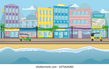 Asian street with colorful buildings, electric wires and tuk tuks on the roads. The seafront promenade.
